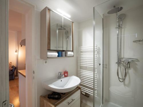 a white bathroom with a sink and a shower at Rosenhof am See Ferienwohnung Enzian in Thiersee