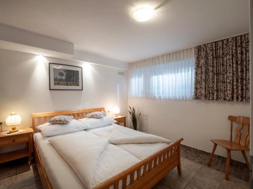 ein Schlafzimmer mit einem Bett, zwei Tischen und einem Fenster in der Unterkunft Rosenhof am See in Thiersee