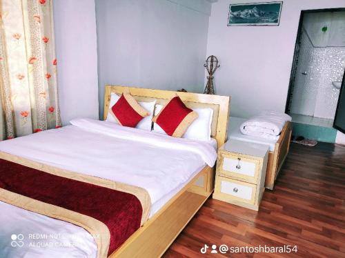 um pequeno quarto com uma cama e uma mesa de cabeceira em Lake View Lodge Sarangkot em Pokhara