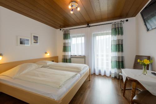 a bedroom with a large bed and a table at Landgasthof Postwirt in Lam