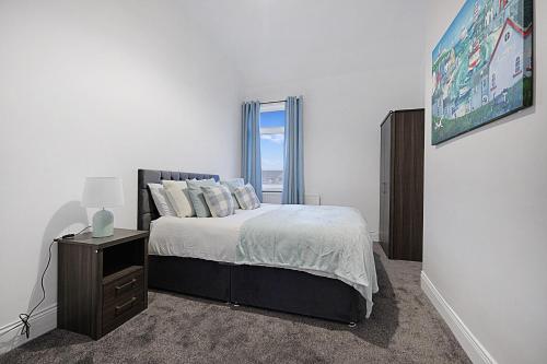 a white bedroom with a bed and a window at Newly refurbished Near the coast Sleeps 5 in Newbiggin-by-the-Sea