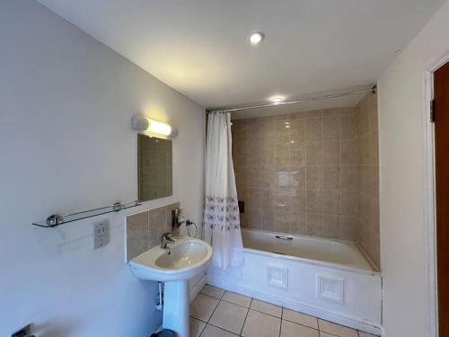 a bathroom with a sink and a bath tub at Partridge in Lyddington