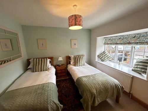 a bedroom with two beds and a window at Partridge in Lyddington