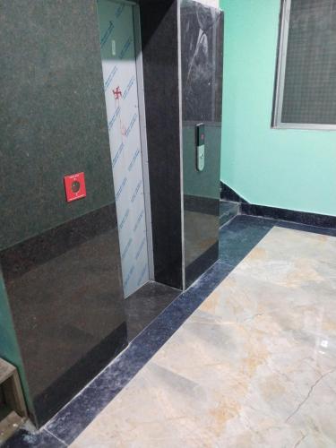 a bathroom with a mirror on the wall and a tile floor at Hotel Jyoti in Madhubani