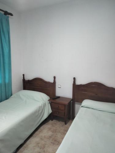 um quarto com 2 camas e uma mesa de cabeceira entre 2 camas em Hostal Júcar em Añover de Tajo