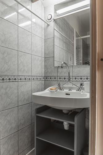 une salle de bain avec un lavabo et un miroir dans l'établissement Maison place de la Pieta, à Chirac