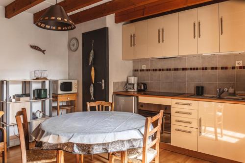 une cuisine avec une table et des chaises dans une pièce dans l'établissement Maison place de la Pieta, à Chirac