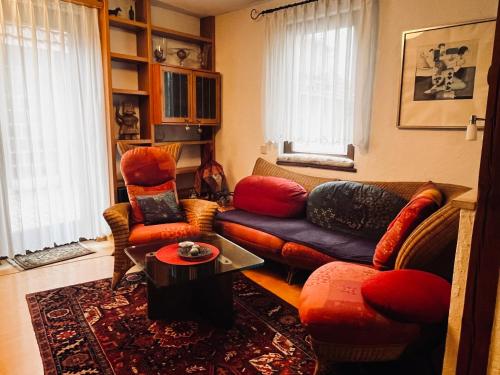 a living room with a couch and chairs and a table at Torbogenhäuschen im Herzen von Ruit in Ostfildern