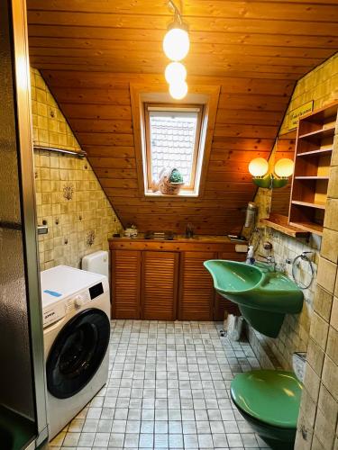 a bathroom with a green sink and a washing machine at Torbogenstübchen in Ostfildern