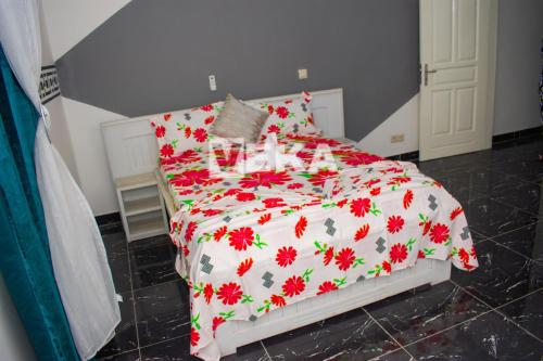 1 dormitorio con 1 cama con manta roja y blanca en Appartement Chic, en Pointe-Noire