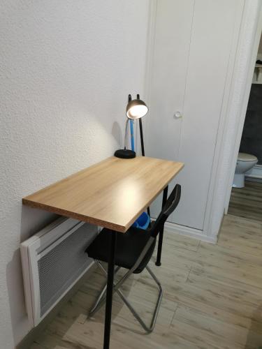 a desk with a lamp sitting on top of it at Studio meublé équipé calme et bien situé in Chambray-lès-Tours