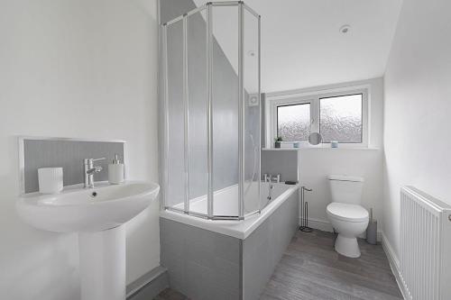 Baño blanco con lavabo y aseo en Chic Retreat Coastal Town Sleeps 4 en Saltburn-by-the-Sea