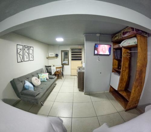 un salon avec un canapé et une table dans l'établissement Hospedagem Recanto dos Viajantes, à Bom Jardim da Serra