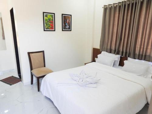 a bedroom with a white bed with a flower on it at Hotel Sai Sneha in Shirdi