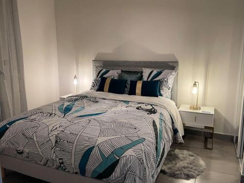 a bedroom with a large bed with a comforter at PRADO PLAGE DAVID - MARINA OLYMPIQUE JO 2024 - STADE VELODROME - PARC BORELY - LA CORNICHE- CLUB NAUTIQUE - appartement situé à 800m de JO 2024 et à 10m de plage -Luxury apartment by the Sea in Marseille