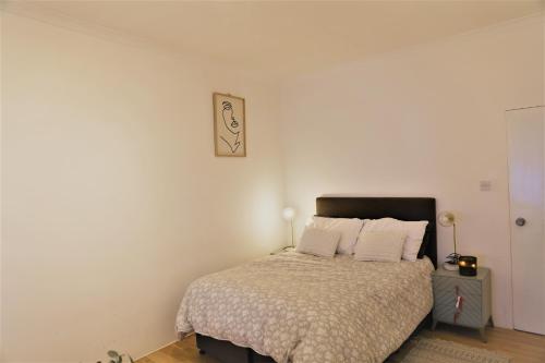 ein Schlafzimmer mit einem Bett und einem Bild an der Wand in der Unterkunft Cozy place Soho London in London