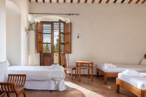 una habitación con dos camas y una ventana en Flateli Casa Indiana, en Bordils