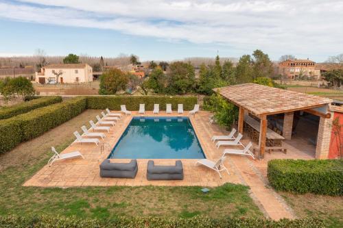 - une vue sur la piscine avec des chaises et un pavillon dans l'établissement Flateli Casa Indiana, à Bordils