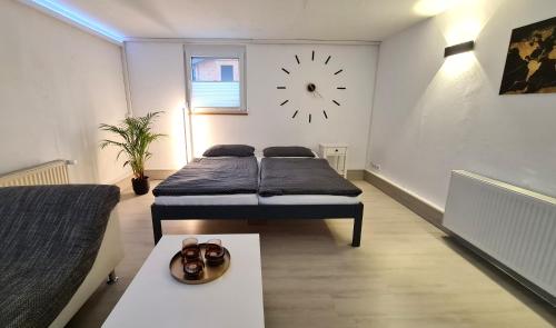 a bedroom with two beds and a clock on the wall at Wohnung am HELLER in Nürtingen