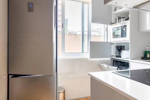 a stainless steel refrigerator in a white kitchen at Lisbon Breezy Haven 2Bedroom Oasis in Lisbon