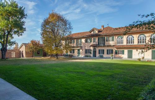 une grande maison avec une pelouse verte en face de celle-ci dans l'établissement Villa Fogliacchi, à La Morra