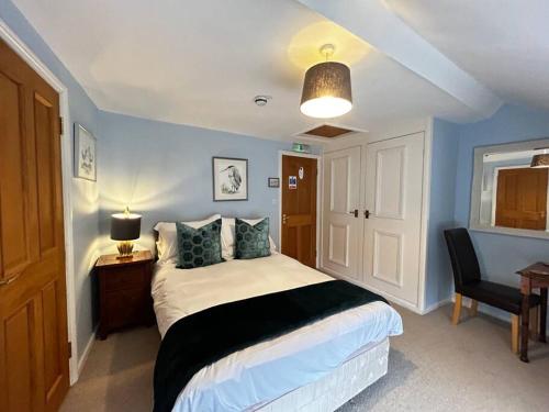 um quarto com uma cama, uma mesa e um candeeiro em Quail em Lyddington
