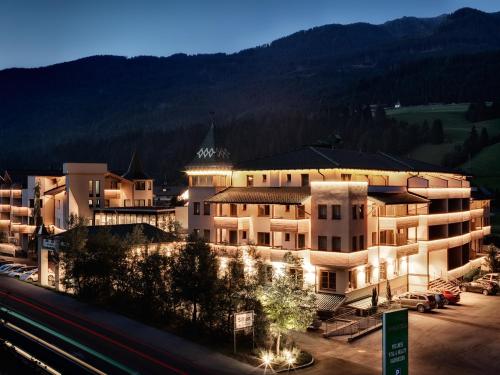 a large building is lit up at night at Dolomiten Residenz - Sporthotel Sillian in Sillian