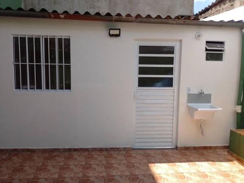 a white house with a sink and a window at Casa com churrasqueira para Lollapalooza in Sao Paulo