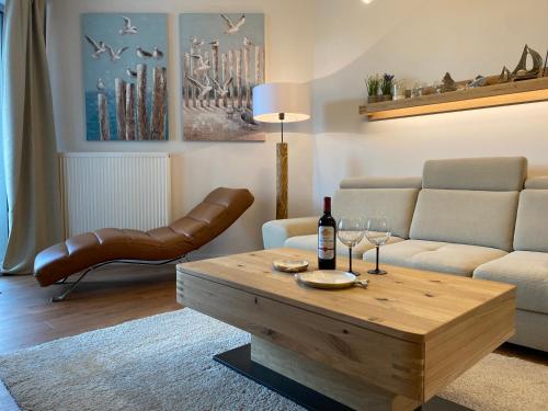 a living room with a couch and a table with wine glasses at Apartament Premium PINEA 316 in Pobierowo