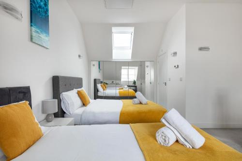 a bedroom with two beds with yellow and white at NEW Luton 3 Bedroom house, Contractors & families, Sleeps 7 with Free Parking & WIFI in Luton