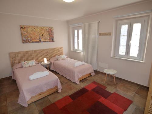 2 Betten in einem Zimmer mit 2 Fenstern in der Unterkunft Casina di Andrea with above ground pool, Capannori in Capannori