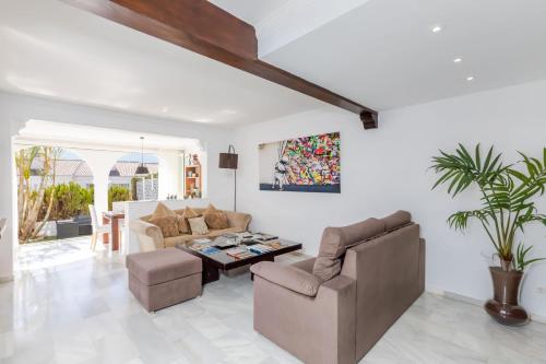 uma sala de estar com um sofá e uma mesa em Casa Jardines del Sol J5 em Marbella