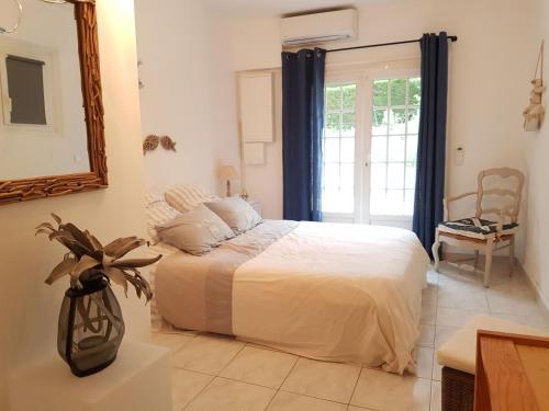 une chambre avec un grand lit et un miroir dans l'établissement tourillonne, aux Issambres