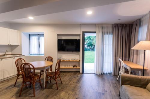 cocina y sala de estar con mesa y sillas en Le Petit Apartamentos en Santander