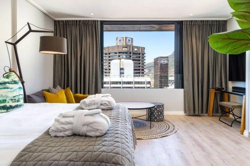 een hotelkamer met een bed en een groot raam bij Cape Town Bree Street 27th Floor Studio Apt Views in Kaapstad