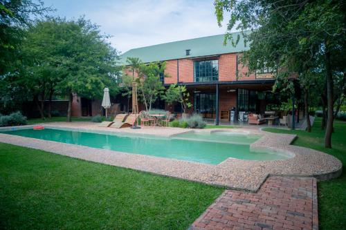 a building with a swimming pool in the yard at Kamps Apartment - Foxdale Forest in Lusaka