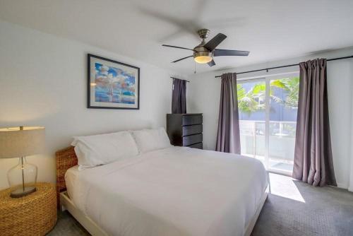 a bedroom with a bed with a ceiling fan and a window at Bay Shores in San Diego