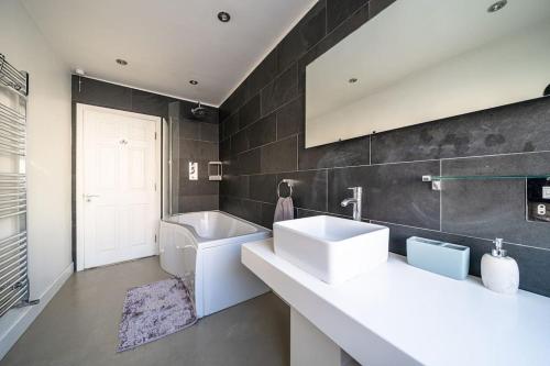 ein Badezimmer mit 2 Waschbecken und einer Badewanne in der Unterkunft 2 Bed Central Tunbridge Wells in Royal Tunbridge Wells