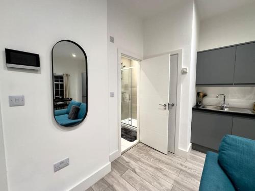 sala de estar con espejo y sofá azul en Hotel Studio Escape in Kent en Kent