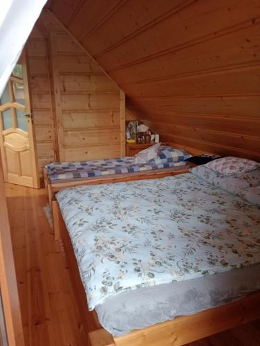 een slaapkamer met 2 bedden in een blokhut bij Drewniana chatka in Budy Stare
