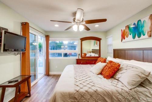 a bedroom with a bed with a ceiling fan and a television at Bay View in San Diego