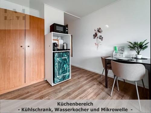 eine Küche mit einem Kühlschrank und einem Tisch im Zimmer in der Unterkunft LM-ApartmentsMainz-07 in Mainz