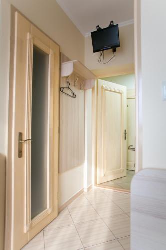 a room with an open door and a tv on the wall at Tulipan Hotel Aquapark in Vyshkove
