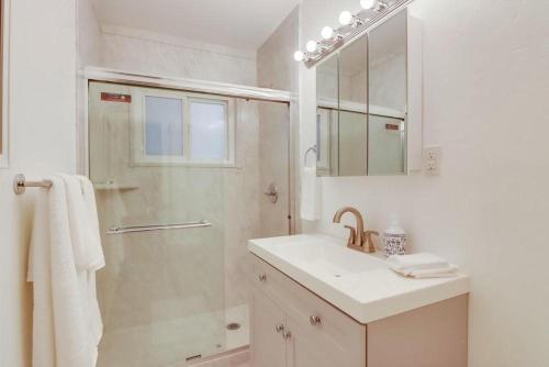 uma casa de banho branca com um lavatório e um chuveiro em Bayside 1 em San Diego