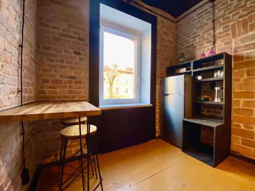 uma cozinha com um balcão, um frigorífico e uma janela em Zielona Park Industrial Studio em Dabrowa Górnicza