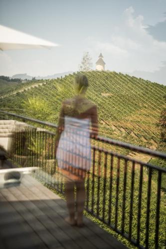 a woman standing on a bridge looking at a vineyard at Winzer Appartements Kogler in Leutschach