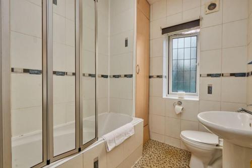 y baño con bañera, aseo y lavamanos. en Comfy Home on Burton Road en Derby