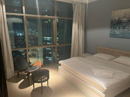 una camera con un letto e una sedia e una finestra di Modern 2BR Apart DIFC Downtown World Trade Center a Dubai
