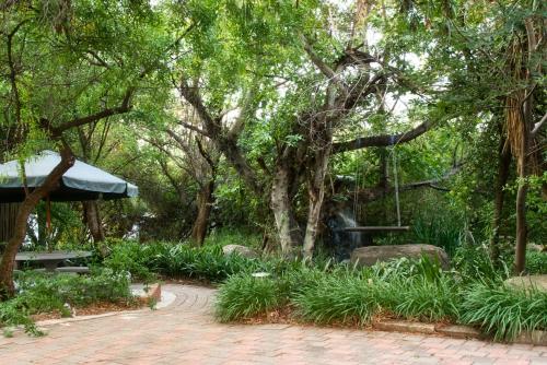 a park with a bench and trees and plants at Glenda's Guest Suites in Midrand