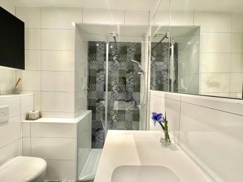 une salle de bain blanche avec toilettes et douche dans l'établissement Gallia Park by Welcome to Cannes, à Cannes